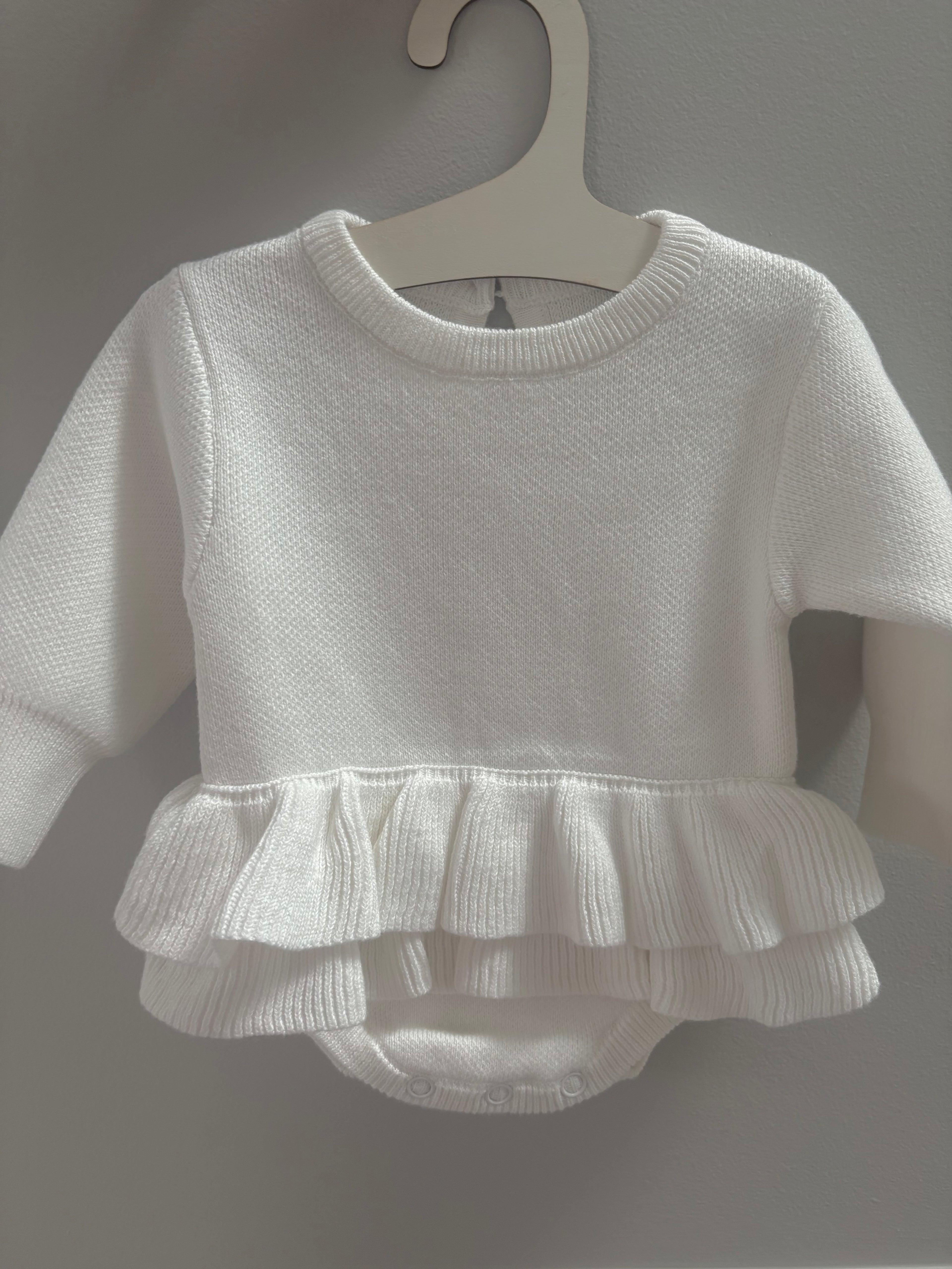 White baby romper with ruffled edge detail