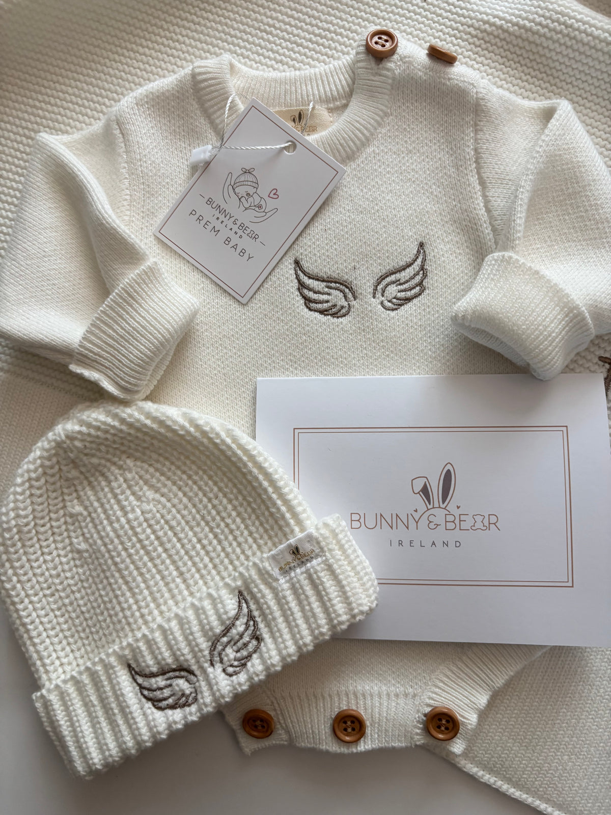 ivory knitted premature baby romper and matching hat embroidered with angel wings, part of the bunny and bear remembrance collection